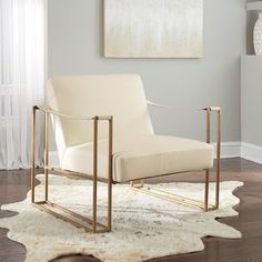 a white chair sitting on top of a wooden floor next to a painting and rug