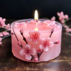 a pink candle sitting on top of a wooden table