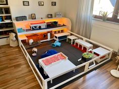 a living room filled with lots of furniture and toys on top of a hard wood floor