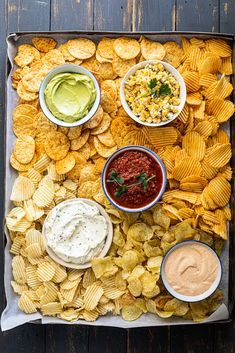 a tray filled with chips and salsa dips