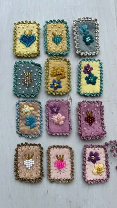 many square pieces of fabric with flowers and butterflies in them on a white tablecloth