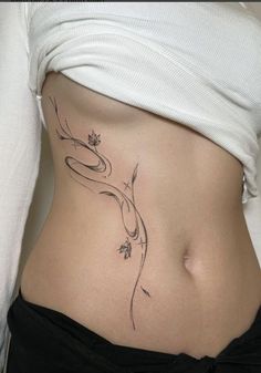 a woman's stomach with a flower tattoo on her side and the bottom part of her belly