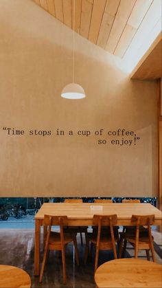 a table and chairs in a room with a quote on the wall above it that says time stops in a cup of coffee so enjoy