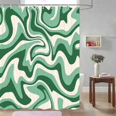 a green and white shower curtain with an abstract design on the front, in a bathroom