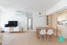 a living room filled with furniture and a flat screen tv on top of a wooden table