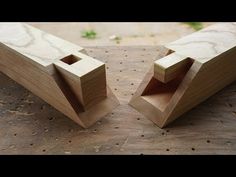 two pieces of wood sitting on top of a wooden table next to each other with holes in them