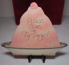 a sign that says please come to my party on top of a plate with an object in the background