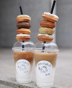 three donuts are stacked on top of each other in plastic cups with straws