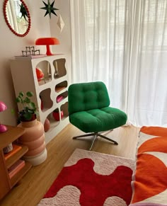 a green chair sitting on top of a wooden floor next to a red and white rug