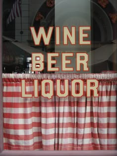 a window with red and white checkered curtains in front of it that says wine beer liquor