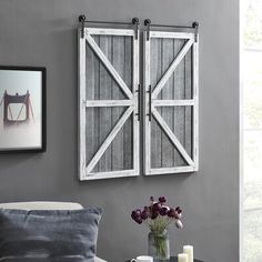 a living room with gray walls and white shutters on the wall, coffee table