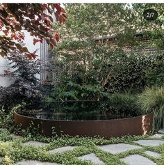 an outdoor garden with stone walkway and water feature