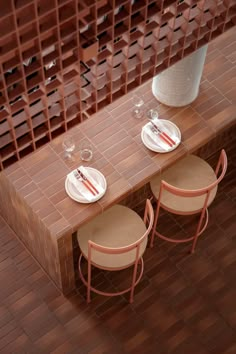 two empty plates sit on top of a long table with three chairs at the end