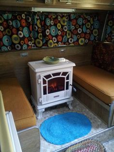 a small stove in the corner of a room with two couches and a rug on the floor