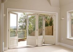 an empty room with two windows and a sliding glass door