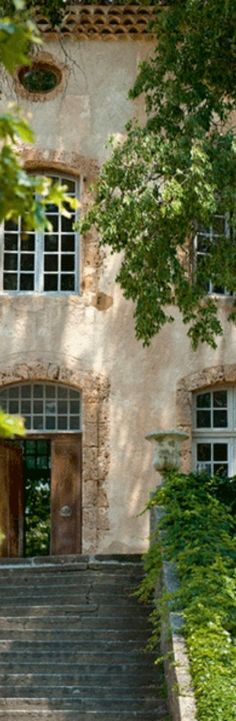 an old building with steps leading up to the front door and two windows on each side