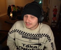 a young man wearing headphones while sitting down