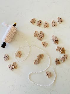 buttons and thread laid out on a white counter top next to a spool of thread