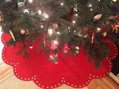 a christmas tree with ornaments on it and lights in the top right hand corner is a red placemat