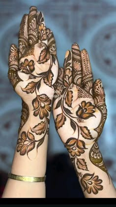 two hands with henna designs on them