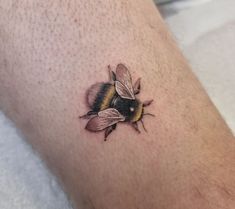 a small tattoo of a bee on the leg