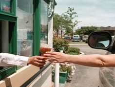 two people reaching out their hands to each other in front of a storefront window