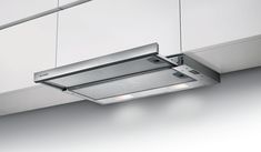 a kitchen hood mounted on the side of a wall above a stove top oven with two lights