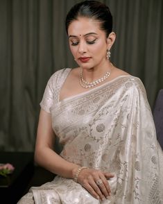 a woman in a white sari sitting down