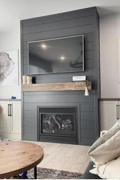 a living room with a fireplace and tv mounted on the wall