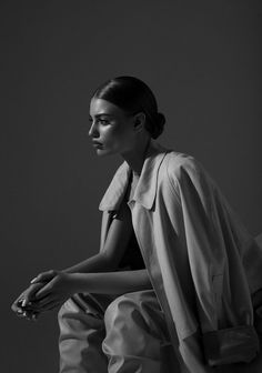 a black and white photo of a woman sitting down