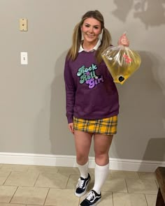 a girl in a purple shirt and yellow skirt holding a bag