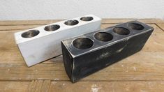 two metal containers sitting on top of a wooden table