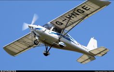 a small airplane flying through a blue sky with the word g - wing on it's side