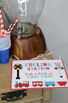 there is a sign that says fueling station and two cups with straws next to it