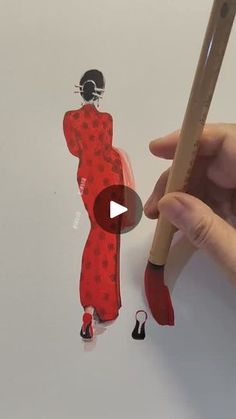 a person holding a pencil and drawing a woman in a red dress with polka dots