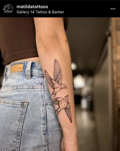 a woman's arm with a bird tattoo on the left side of her body