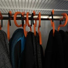 there are many coats and jackets hanging on the rack