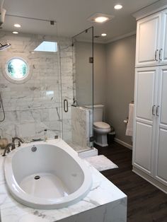 a large white bath tub sitting next to a walk in shower