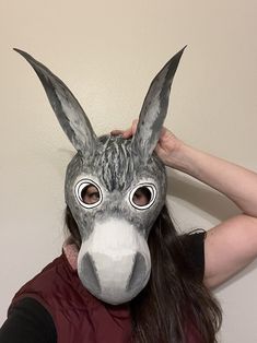 a woman wearing a donkey mask with long hair