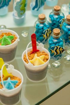 there are three cups filled with cereal and starfish on the table next to each other