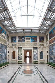 the inside of a building with paintings on the walls and ceiling, along with potted plants