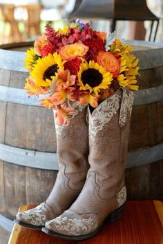 cowboy boots with sunflowers and roses in them