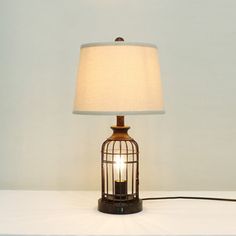 a lamp that is sitting on top of a white table next to a light bulb