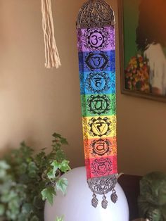 a tall pole with seven chakras on it in front of a potted plant