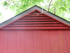 the top of a red building with a bird perched on it's roof