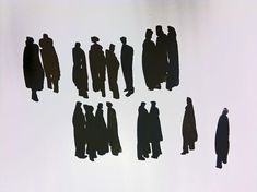 several silhouettes of people standing in the middle of a white wall with black shadows on it