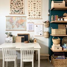 a white table and chairs in a room with many pictures on the wall above it