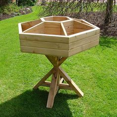 a wooden planter sitting on top of a lush green field