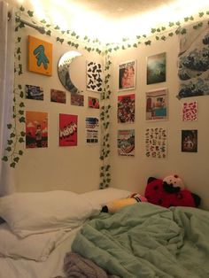 a bedroom with pictures on the wall and a stuffed animal laying in bed next to it