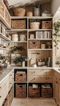 a kitchen with lots of baskets on the shelves and cupboards filled with books, plants and other things